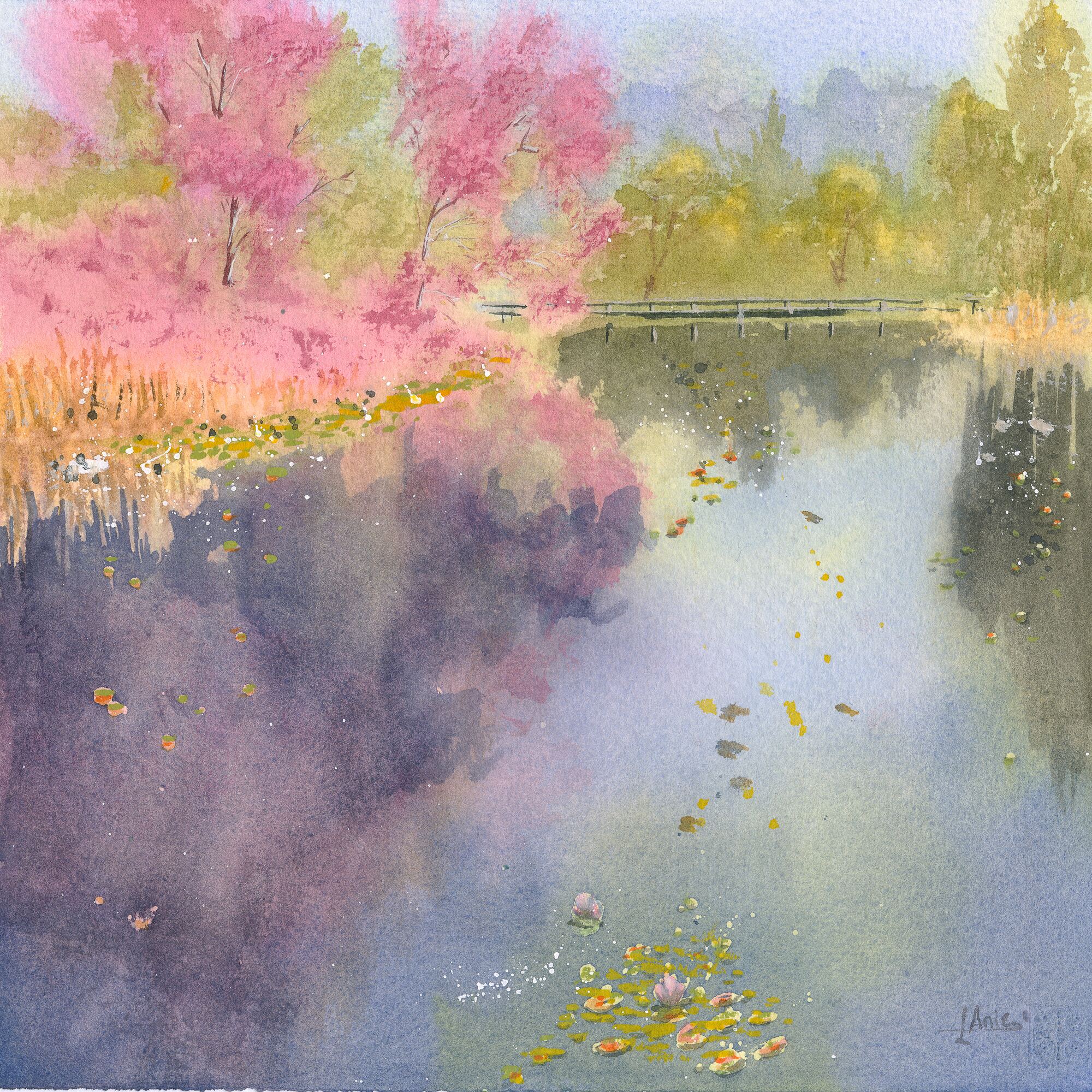 pink-blossoming trees and golden reeds reflected in a still lake, with water lilies and a small wooden footbridge